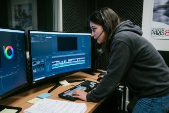 Étudiante en cinéma travaillant sur un logiciel de montage vidéo dans une salle de post-production universitaire à Nantes