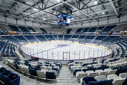Vue intérieure d'une patinoire de type arena avec gradins et glace vierge, illustrant les infrastructures sportives de Grenoble